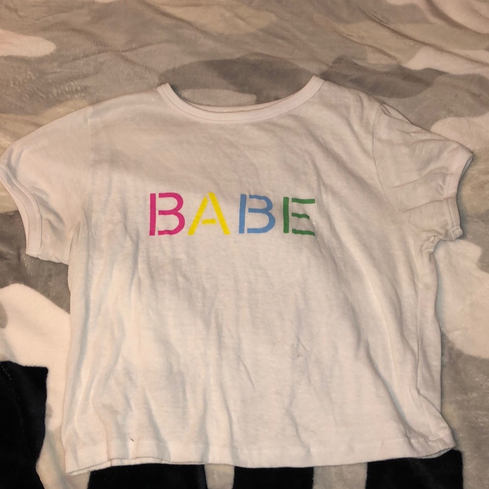 white shirt, says “babe”